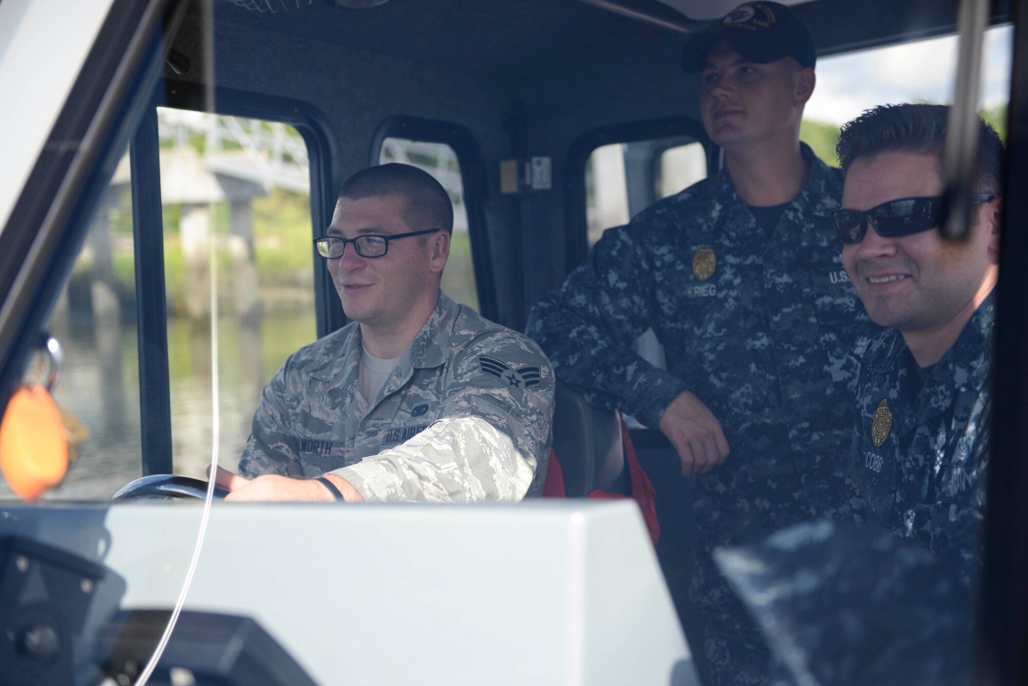 Senior Airman Austin Walworth conducts training with Master at Arms 1st Class Jeremy Krieg and Master at Arms 1st Class Brian Cobb on a Harbor Patrol Unit boat embedded with the 628th Security Forces Squadron at Joint Base Charleston, S.C. Walworth recently earned the Navy Small Craft Insignia, or Coxsain Pin, and is believed to be the first Airman to earn the distinction. (U.S. Navy Photo by Mass Communication Specialist 2nd Class John Haynes/Released)