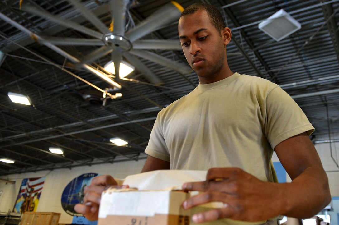 U.S. Air Force Airman 1st Class Xavier Hill, 20th Logistics Readiness Squadron outbound cargo apprentice, prepares a package for delivery at Shaw Air Force Base, S.C., Aug. 22, 2016. Airmen assigned to the 20th LRS inbound and outbound cargo flights help ensure that mission-associated gear from around base are properly packed, labeled and ready for delivery. (U.S. Air Force photo by Airman 1st Class Christopher Maldonado)