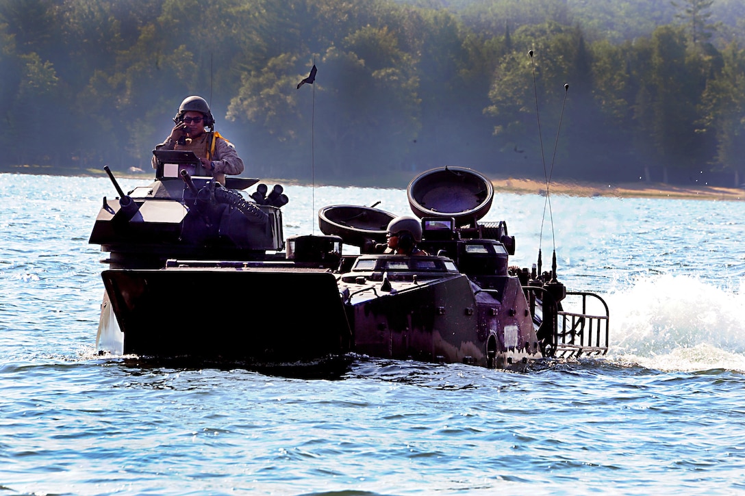 Marines communicate with comrades on the shore during an amphibious assault exercise on Lake Margrethe during Exercise Northern Strike 16 at Camp Grayling, Mich., Aug. 11, 2016. Michigan Army National Guard photo by Sgt. 1st Class Helen Miller