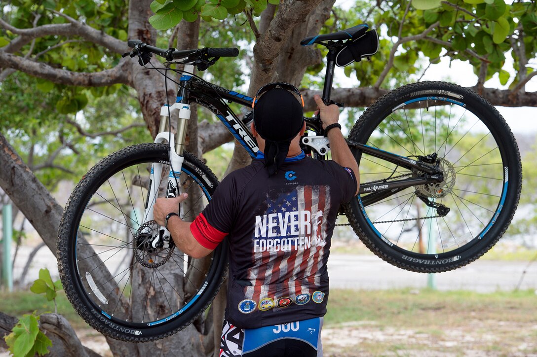 Iraqi Freedom veteran Army Master Sgt. David Camacho hangs a mountain bike on a tree in Cabo Rojo, Puerto Rico, Aug. 13, 2016. Camacho and other veterans rode with the Warriors 4 Life nonprofit veterans group, which helps veterans cope with physical and psychological wounds and creates healthy lifestyles for them and their families. DoD photo by EJ Hersom
