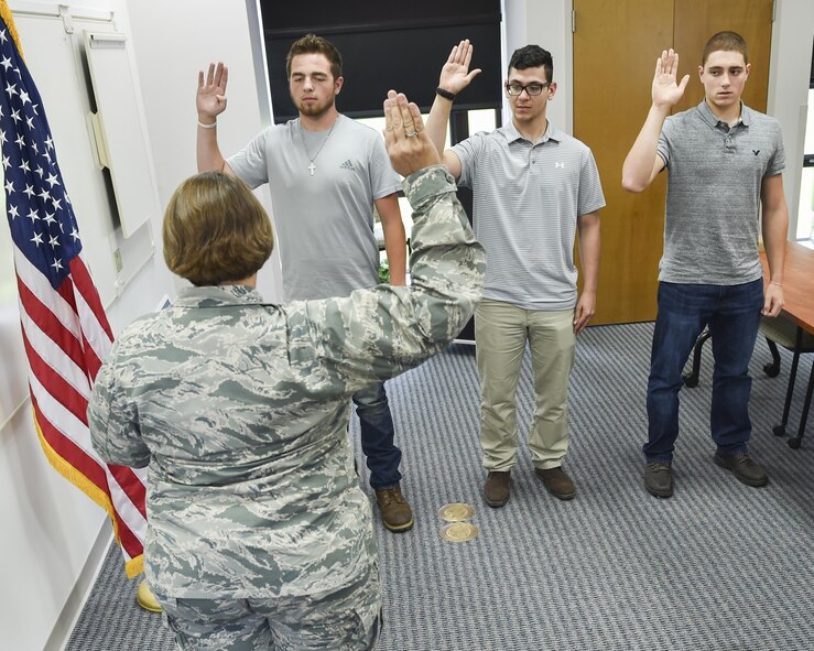 Michael Amato, Cross Scarpaci and Dan Madeline raise their right hands and recite the oath of enlistment following the lead of public affairs officer Maj. Polly Orcutt here, Aug. 19, 2016. Master Sgt. Joseph Poltor, a Youngstown Air Reserve Station recruiter, recruited the three new Airmen. Poltor recently made 150 percent of his recruitment quota, becoming the third Youngstown recruiter in recent history to reach the Century Club. (U.S. Air Force photo/Eric White)