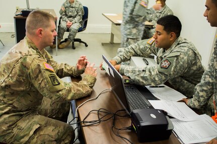 FORT MCCOY, Wis. - U.S. Army Reserve Soldier Spc. Jason Norwood (left) with 962d Ordnance Company Headquarters, participates in a training scenario at a cashier station manned by Pvt. Jacob Salazar from the 374th Financial Management Support Unit Detachment 4. Soldiers from multiple units train in finance operations as part of Exercise Diamond Saber in August 2016 on Fort McCoy, Wis. (U.S. Army Reserve Photo by Sgt. Clinton Massey, 206th Broadcast Operations Detachment)