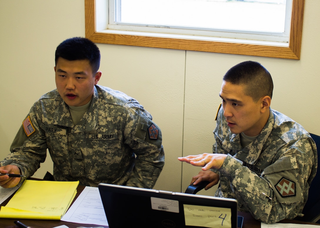 FORT MCCOY - During Exercise Diamond Saber, U.S. Army Reserve Soldiers Pvt. Joshua Park (left) and Spc. Sunkyo Kim (right) with the 374th Financial Management Support Unit Detachment 4 of New Cumberland, Pa., train to solve military pay issues August 2016 at Fort McCoy. Soldiers work with various units in mock exercises to hone their skills. (U.S. Army Reserve Photo by Sgt. Clinton Massey, 206th Broadcast Operations Detachment)