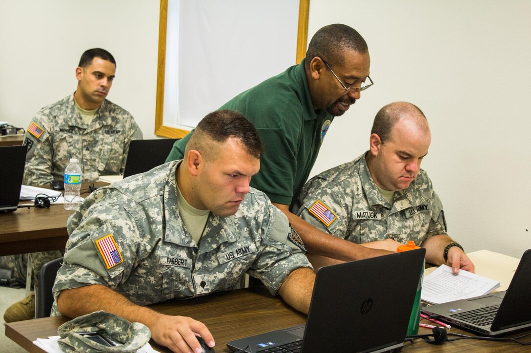 FORT MCCOY, Wis. - National Guard Soldiers of 176th Finance Management Detachment, from Indianapolis, Ind., receive instruction from John Payne, (center), the Deputy Director of Defense Military Pay Office from Fort Sam Houston, Texas. Soldiers from all U.S. Army components learn how to process live military pay documents while attending Exercise Diamond Saber in August 2016. (U.S. Army Reserve Photo by Sgt. Clinton Massey, 206th Broadcast Operations Detachment)