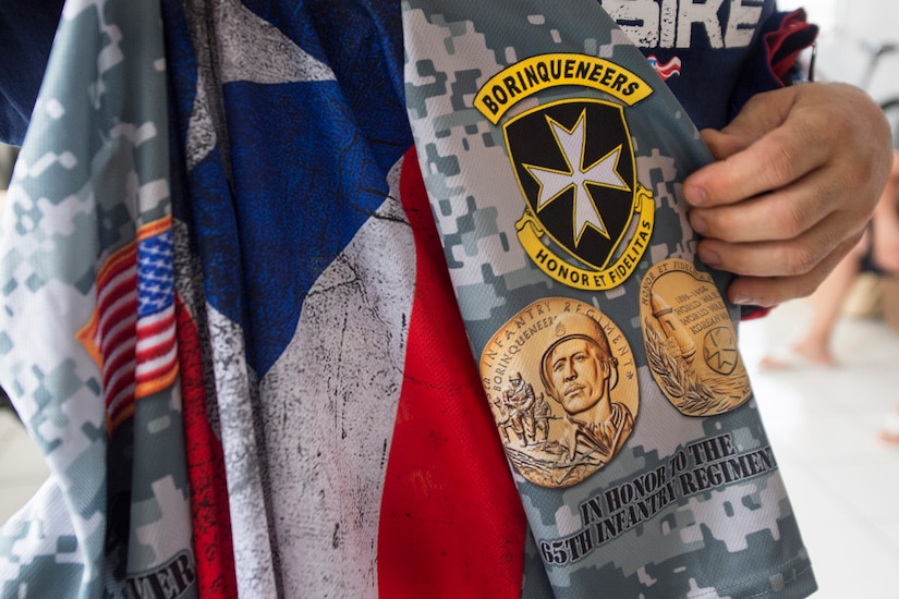 A veteran holds a bicycle jersey with an imprinted emblem of Puerto Rico's 65th Infantry Regiment in Cabo Rojo, Puerto Rico, Aug. 13, 2016. Veterans riding with the Warriors 4 Life nonprofit veterans group dedicated their ride in a 100-kilometer mountain bike race to the regiment famous for its bayonet charge in the Korean War. DoD photo by EJ Hersom
