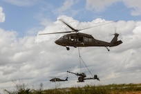 Flight crews from the 8-229th Assault Helicopter Battalion conduct sling load operations with elements from the 1-163 Field Artillery Regiment of the Indiana National Guard. (Photo by Renee Rhodes / Fort Knox Visual Information).