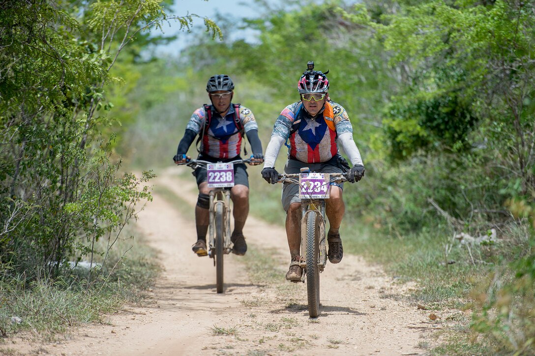 Iraqi Freedom veteran Army Staff Sgt. Carlos Labarca and Puerto Rico Army National Guard Staff Sgt. Juan Gonzalez ride a trail in a 100-kilometer mountain bike race in La Parguera, Puerto Rico, Aug. 14, 2016. DoD photo by EJ Hersom
