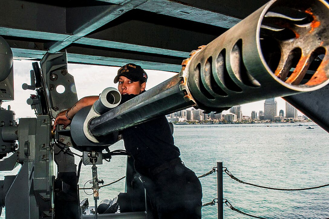 Navy Petty Officer 3rd Class Kristen Neufeld performs maintenance on a Mark 38-25 mm machine gun aboard the aircraft carrier USS Carl Vinson at its home port in San Diego, Aug. 18, 2016. Navy photo by Seaman Theo Shively