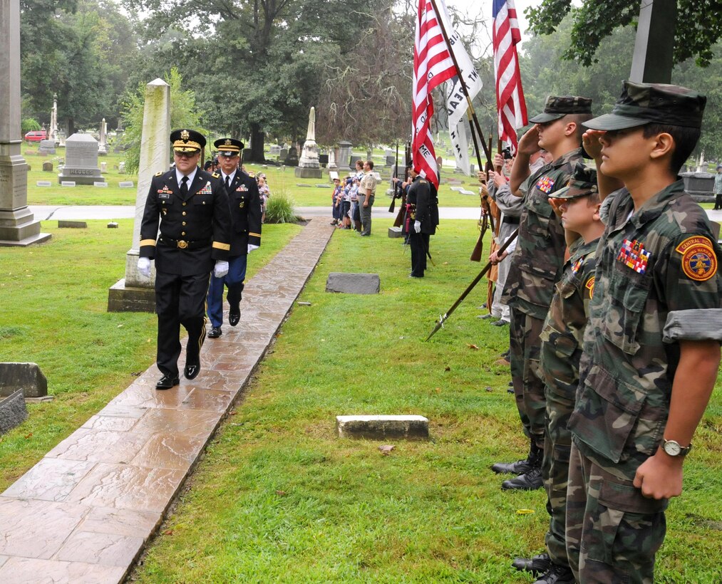 Brigadier Gen. Stephen E. Strand, front left, deputy commanding general, 88th Regional Support Command, and Chaplain (Maj.) Scott Hagen, deputy command chaplain, 88th RSC, march past the formation of ceremonial re-enactors, Young Marines and Cub and Boy Scouts during the President Benjamin Harrison wreath laying ceremony in Indianapolis, August 20, on what would have been Harrison’s 183rd birthday.