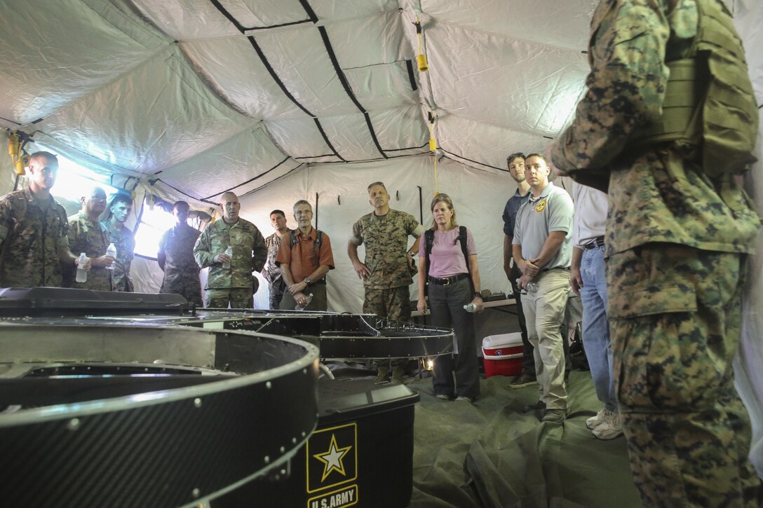 Distinguished visitors from the Department of Defense receive a brief on the Joint Tactical Aerial Resupply Vehicle at Camp Lejeune, N.C., Aug. 17. This version of the JTARV can carry up to 200 pounds, which can potentially allow for faster resupply missions on the battlefield. Alan Estevez, Principal Deputy under Secretary of Defense for Acquisition, Technology and Logistics, Kristin French, Principal Deputy under Secretary of Defense for Logistics and Material readiness, and Lt. Gen. Michael Dana, Deputy Commandant of Installations and Logistics, visited the base to get a first-hand look at logistical innovation throughout II Marine Expeditionary Force. (U.S. Marine Corps photo by Sgt. Lucas Hopkins)