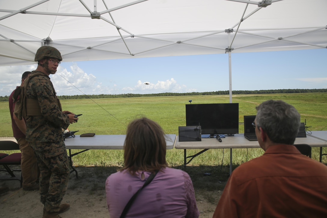 Lance Cpl. Zachary Black, left, a Joint Tactical Aerial Resupply Vehicle operator with Combat Logistics Regiment 25, demonstrates the capabilities of the JTARV to distinguished visitors from the Department of Defense at Camp Lejeune, N.C., Aug. 17. Technological advancements such as the JTARV can potentially allow for safer and quicker resupply missions as opposed to vehicle convoys or piloted aircraft, helping to preserve resources and save lives on the battlefield. (U.S. Marine Corps photo by Sgt. Lucas Hopkins)