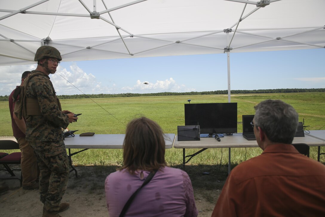 Lance Cpl. Zachary Black, left, a Joint Tactical Aerial Resupply Vehicle operator with Combat Logistics Regiment 25, demonstrates the capabilities of the JTARV to distinguished visitors from the Department of Defense at Camp Lejeune, N.C., Aug. 17. Technological advancements such as the JTARV can potentially allow for safer and quicker resupply missions as opposed to vehicle convoys or piloted aircraft, helping to preserve resources and save lives on the battlefield. (U.S. Marine Corps photo by Sgt. Lucas Hopkins)