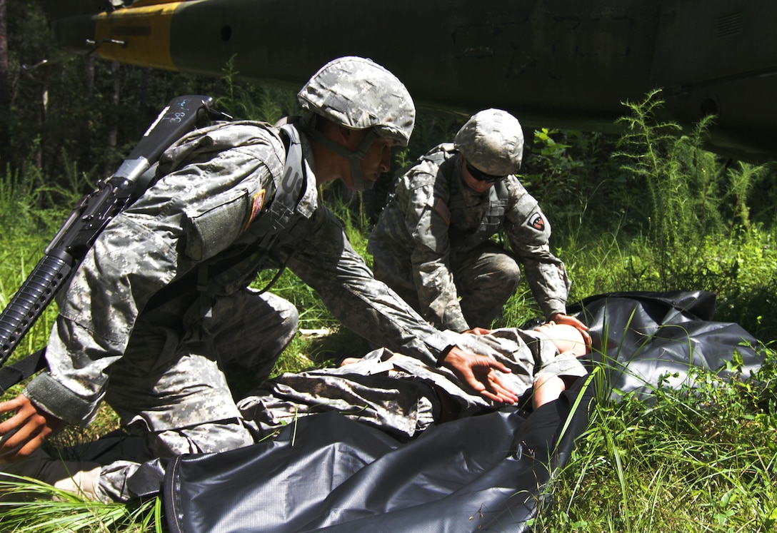 (left) US Army Reserve Spc. Joseph Hernandez, and native of Los Angeles, California, and Pvt. Mario Hernandez, a native of Chino, Calif., both mortuary affairs specialists with the 387th Quartermaster Company – Mortuary Affairs (MA), Los Angeles, Calif., load simulated human remains into a human remains pouch during a Mortuary Affairs Exercise (MAX) at Fort Pickett, Aug. 17. (US Army Reserve Photo by Sgt. Quentin Johnson, 211th MPAD/Released)