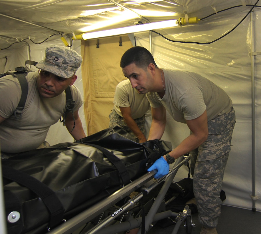 (right) US Army Reserve Spc. Reinaldo Sanchez, a mortuary affairs specialist with the 311th Quartermaster Company – Mortuary Affairs (MA), Puerto Rico, with help of fellow Soldiers secures human remains in a cooler located inside a Mobile Integrated Remains Collection System (MIRCS) during a Mortuary Affairs Exercise (MAX) at Fort Pickett, Aug. 17, 2016. (US Army Reserve Photo by Sgt. Quentin Johnson, 211th MPAD/Released)