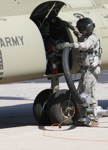 FORT MCCOY, Wis. -- Staff Sgt. Ryan Elkins, a CH-47 Chinook helicopter repairer from Bravo Company, 7th Battalion, 158th Aviation Regiment out of Olathe, Kan., inserts fuel into the helicopter prior to a flight mission as part of the Combat Support Training Exercise in Fort McCoy, Wis., on Aug. 17, 2016. CSTX immerses Army Reserve Soldiers and other service members in real-world training scenarios to enhance unit readiness in the planning, preparation, and execution of combat service support operations. (U.S. Army Reserve photo by Spc. Christopher A. Hernandez, 345th Public Affairs Detachment)