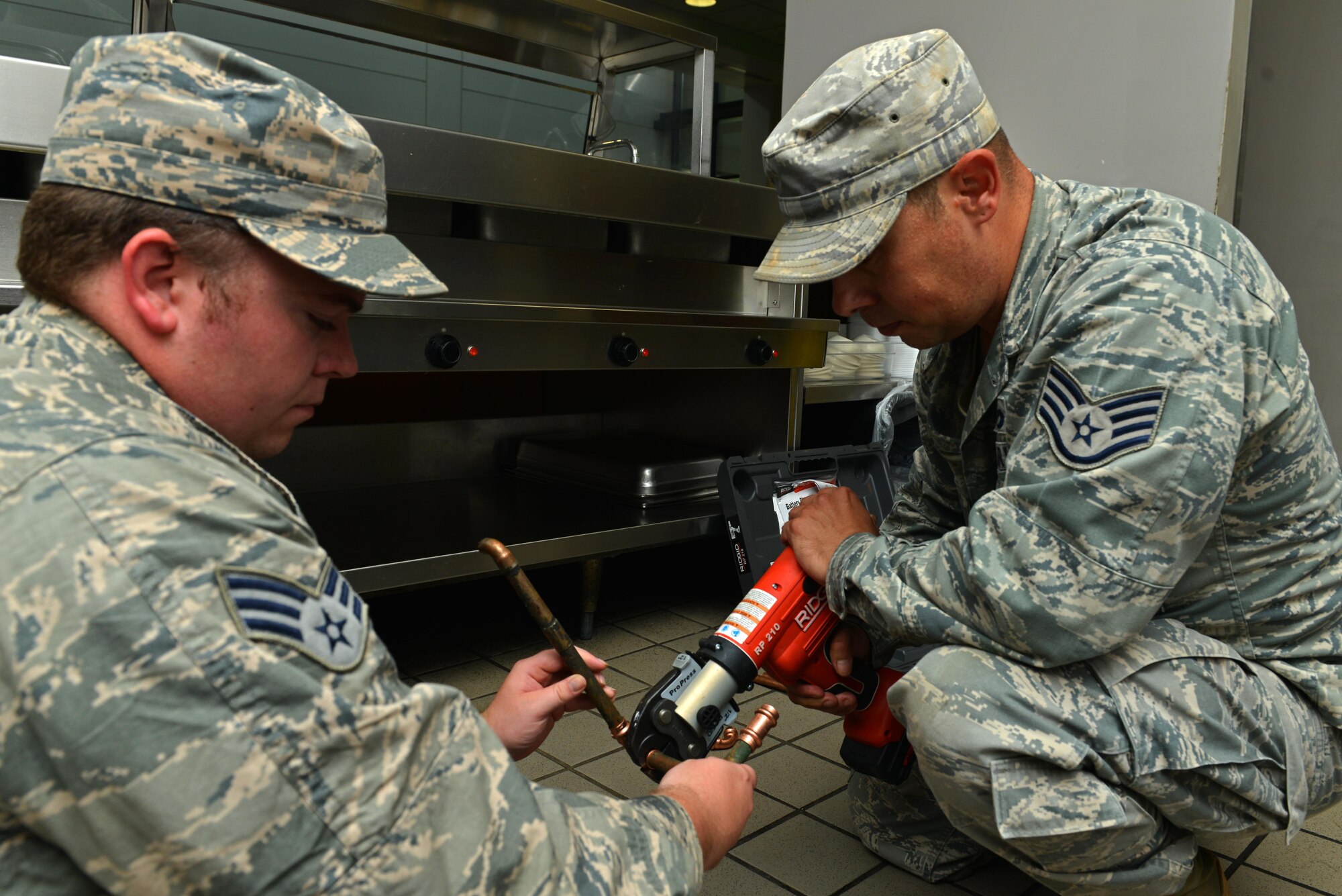 U.S. Air Force Senior Airman Richard Barnes, 20th Civil Engineer Squadron water and fuel systems maintenance journeyman, and Staff Sgt. Jonathan Lucero, 20th CES water and fuel systems maintenance craftsman, repair a pipe in the Chief Master Sgt. Emerson E. Williams Dining Facility at Shaw Air Force Base, S.C., Aug. 18, 2016. The water and fuel systems flight help maintain facilities on base, Wateree Recreation Area and Poinsett Electronic Combat Range. (U.S. Air Force photo by Airman 1st Class Destinee Sweeney)