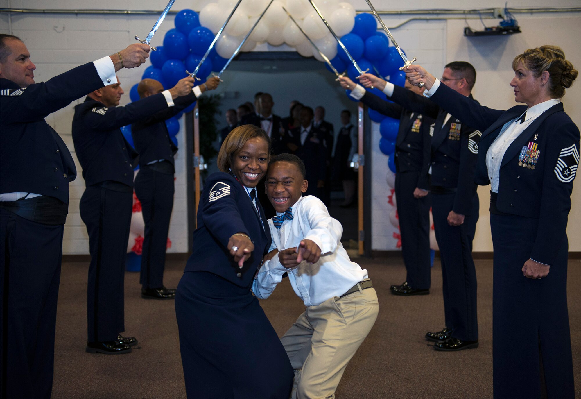U.S. Air Force Master Sgt. Myisha Marks, 23d Wing equal opportunity deputy director, and her son, Brendin, walk through the saber arch during a Senior NCO induction Ceremony, Aug. 20, 2016, at Moody Air Force Base, Ga. Marks was one of approximately 50 Airmen to be recognized during the ceremony, which is a rite of passage for new master sergeant-selects to be honored. (U.S. Air Force photo by Airman 1st Class Greg Nash)