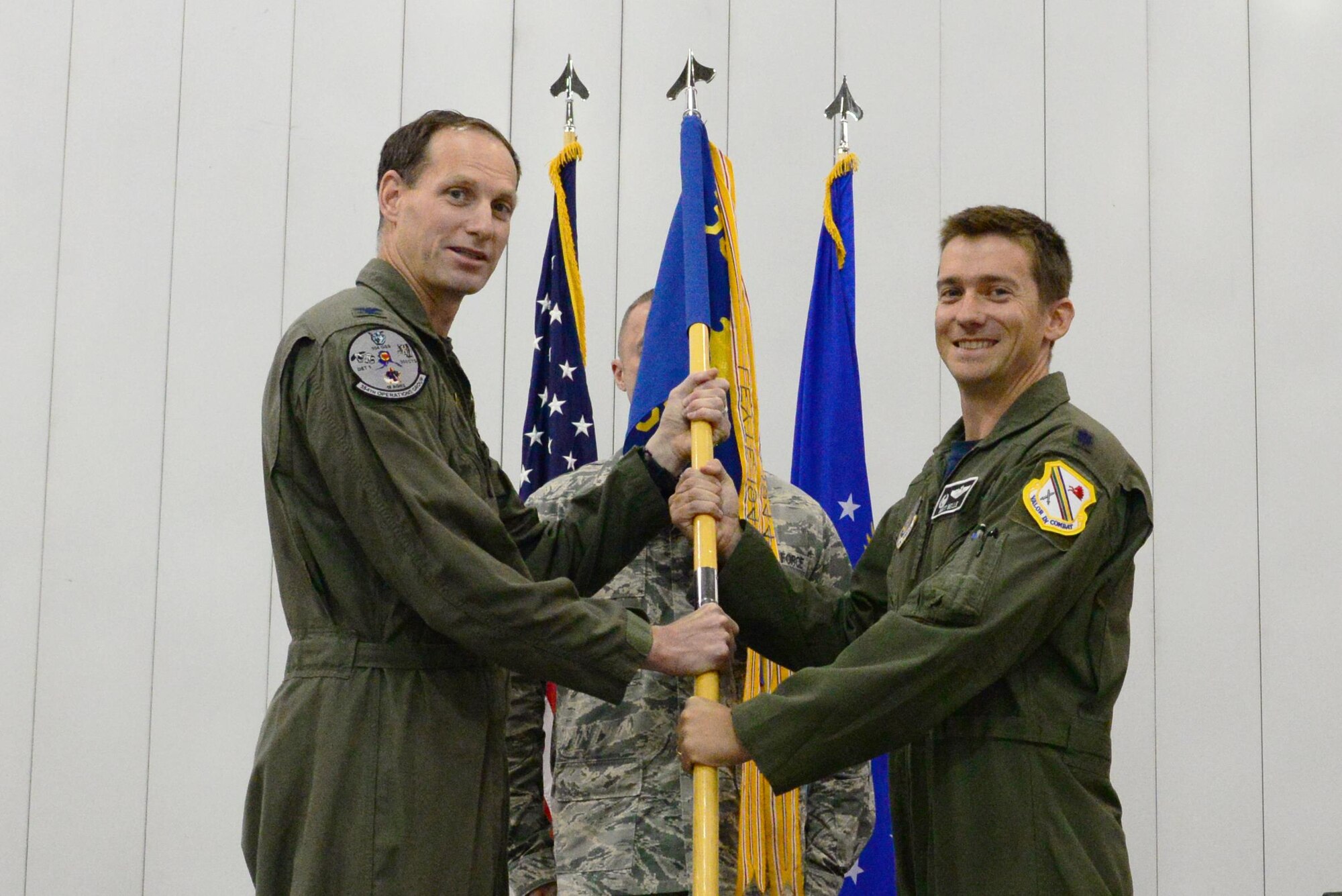 U.S. Air Force Col. Brian Toth, the 354th Operations Group commander, passes the 354th Operations Support Squadron (OSS) guidon to Lt. Col. Matthew Belle, the new 354th OSS commander, Aug. 19, 2016, at Eielson Air Force Base, Alaska. Lt. Col. Micah Bell, the outgoing squadron commander, will remain at the 354th OSS as the director of operations. (U.S. Air Force photo by Airman 1st Class Cassandra Whitman)