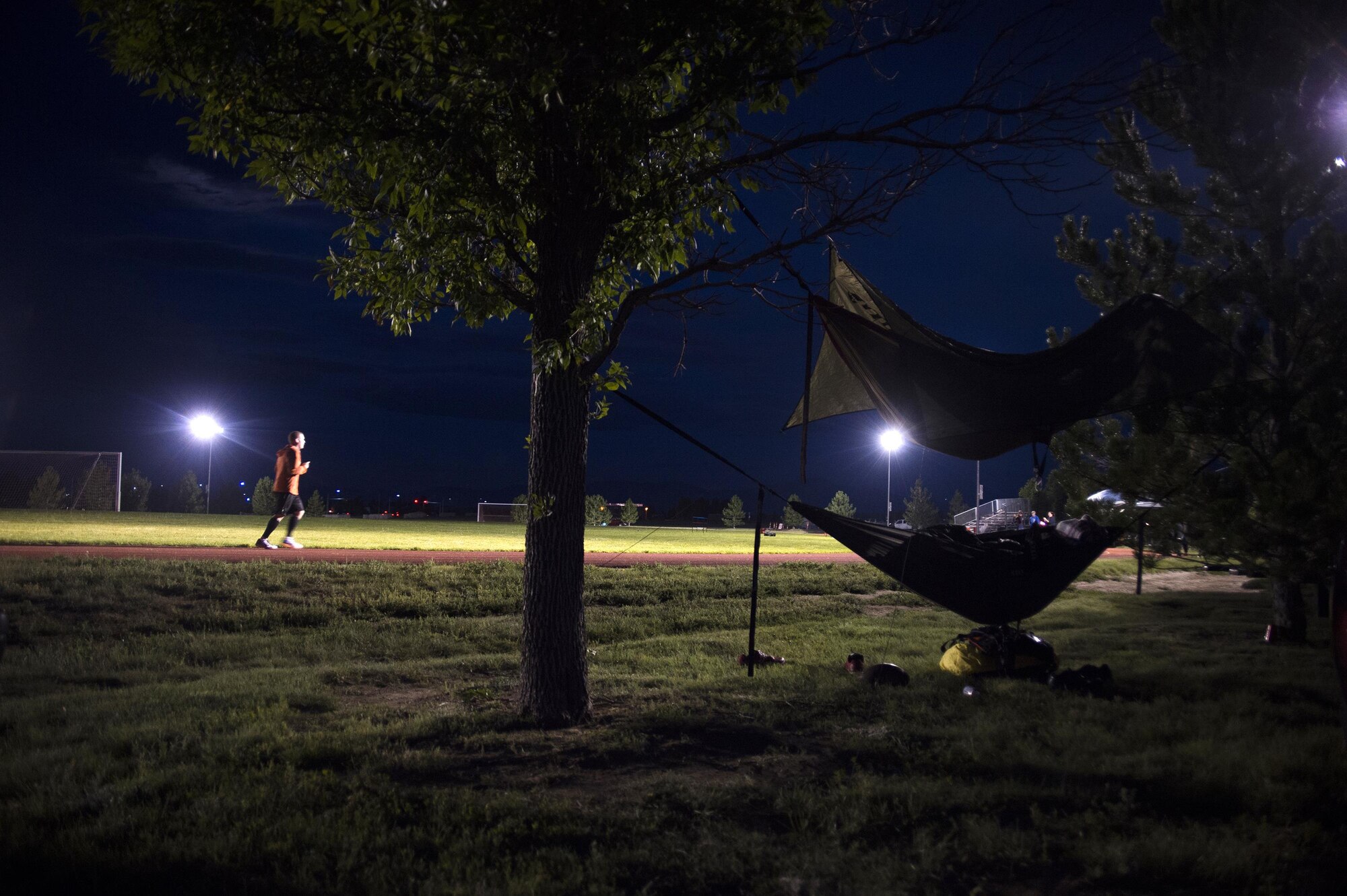 Master Sgt. Blair Burdick, 4th Space Operations Squadron, runs the quarter-mile track early in the morning as other participants sleep in hammocks during Schriever Challenge at Schriever Air Force Base, Colorado, Friday, Aug. 19, 2016. Participating in the challenge hit close to home for Burdick and the rest of 4 SOPS; one of their Airmen was in an accident in April. Fortunately, the family members were able to stay at a Fisher House to be with the Airman. (U.S. Air Force photo/Tech. Sgt. Julius Delos Reyes)
