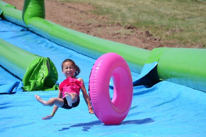 Zoe Allen slips off her tube during Slide the City at Schriever Air Force Base, Colorado, Friday, Aug. 19, 2016. Allen was one of the more than 370 sliders who tubed down the giant slip-and-slide. (U.S. Air Force photo/Brian Hagberg)