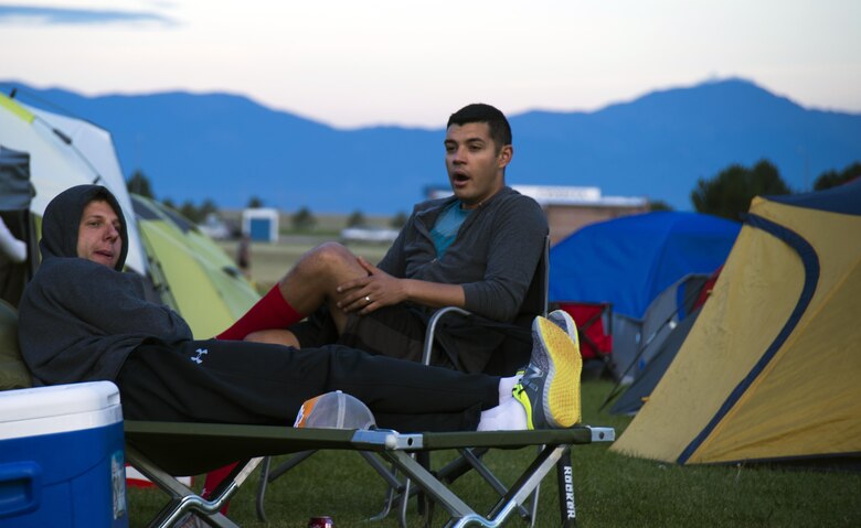 First Lts. Clint Swalls and Christian Figueredo, 3rd Space Operations Squadron, rest before running during Schriever Challenge at Schriever Air Force Base, Colorado, Friday, Aug. 19, 2016. During the event, volunteers provided food and played music to encourage teams to keep moving. (U.S. Air Force photo/Tech. Sgt. Julius Delos Reyes)