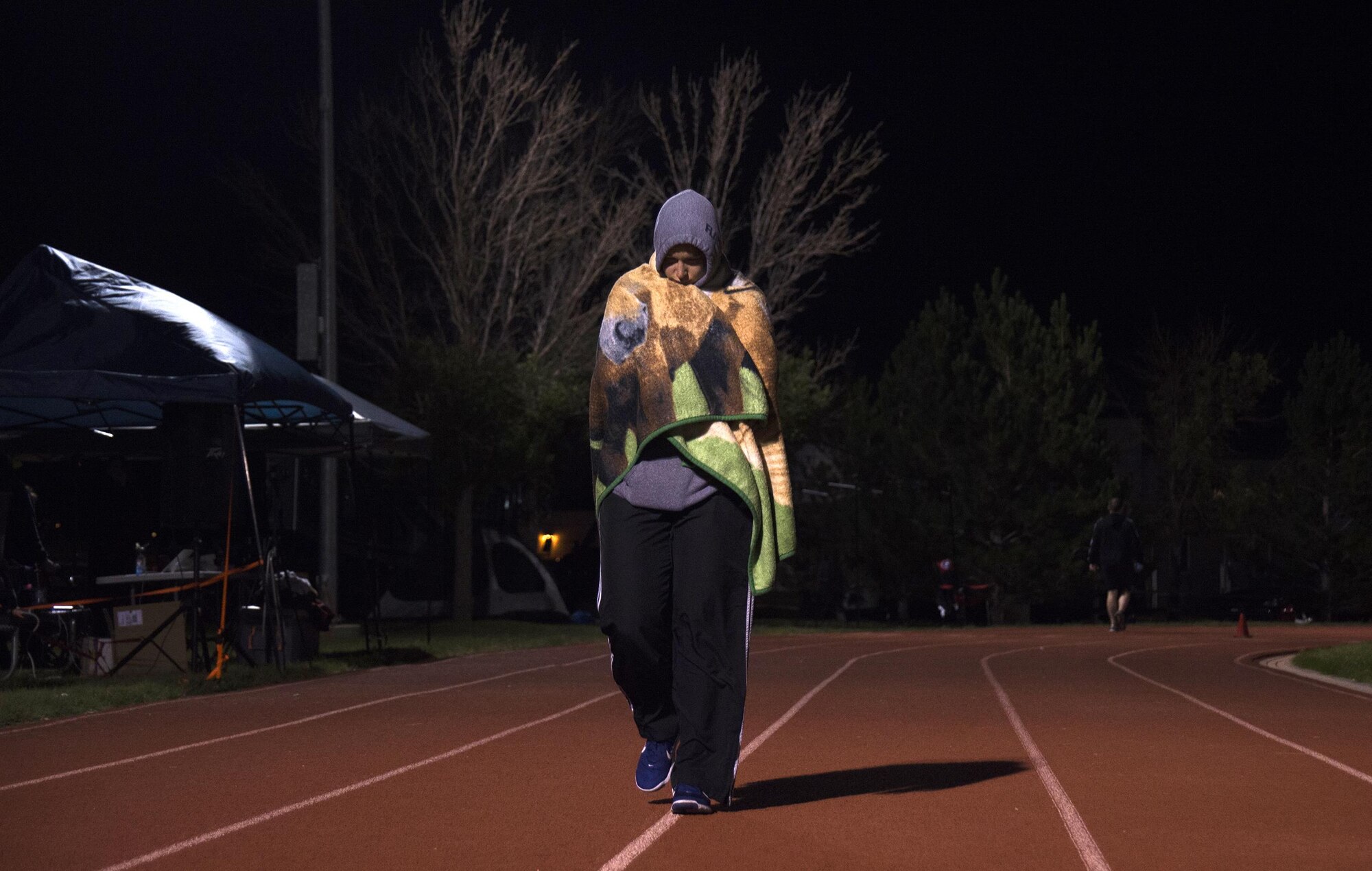 Airman 1st Class Jolene Kalinay, 50th Force Support Squadron, walks the quarter-mile loop wearing a towel for warmth during Schriever Challenge at Schriever Air Force Base, Colorado, Friday, Aug. 19, 2016. The challenge is a 24-hour run and walk relay. (U.S. Air Force photo/Tech. Sgt. Julius Delos Reyes)