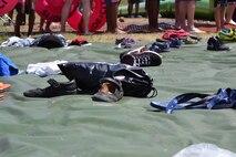 Shoes sit on a tarp while participants prepare to tube down a giant slip-and-slide during Slide the City at Schriever Air Force Base, Colorado, Friday, Aug. 19, 2016. The tarp gave participants a centralized area to place their belongings while they went down the slide. (U.S. Air Force photo/Brian Hagberg)