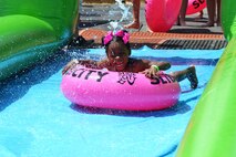 Jasmine Ray slides under a water spout during Slide the City at Schriever Air Force Base, Colorado, Friday, Aug. 19, 2016. Ray was one of the hundreds of Schriever School Age Care and Ellicott School District students who participated in the event. (U.S. Air Force photo/Brian Hagberg)