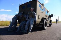 Airmen assigned to the 341st Security Forces Group, push a Humvee during the 5th Annual Ace’s Cop Combat Challenge Aug. 19, 2016, at Malmstrom Air Force Base, Mont. Defenders from across the 341 st Security Forces Group had to complete multiple feats including a Humvee push and a four-man pushup to place in various categories. (U.S. Air Force photo/Airman 1st Class Magen M. Reeves)