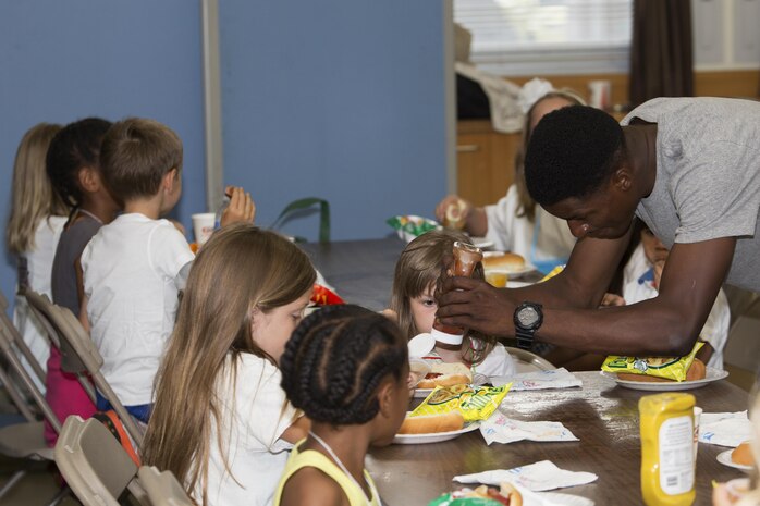 A volunteer helps a child make their hot dog during Vacation Bible School at the Marine Memorial Chapel on Marine Corp Air Station Iwakuni, Japan, Aug. 15, 2016. Before going into rotation stations where the children learned about the bible, they were given an opportunity to eat food prepared and served by the many volunteers from the air station. (U.S. Marine Corps photo by Lance Cpl. Joseph Abrego)