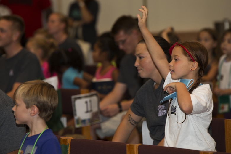 A girl attending Vacation Bible School raises her hand to answer a question at the Marine Memorial Chapel on Marine Corps Air Station Iwakuni, Japan, Aug. 15, 2016. Group discussions were used during VBS to maximize the participation of the children during the event. (U.S. Marine Corps photo by Lance Cpl. Joseph Abrego)