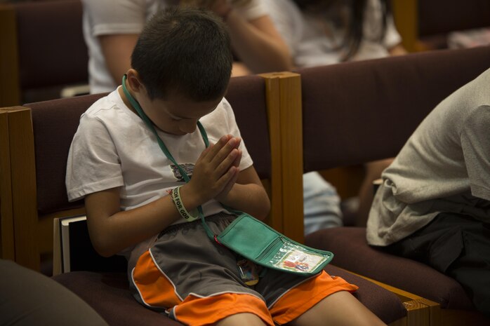 A child prays before getting released to eat during Vacation Bible School at the Marine Memorial Chapel on Marine Corp Air Station Iwakuni, Japan, Aug. 17, 2016. VBS consisted of group discussions, feeding the children and volunteers, praying and rotation stations. (U.S. Marine Corps photo by Lance Cpl. Joseph Abrego)