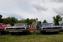 Members from the 5th Aircraft Maintenance Squadron look at some classic cars at the Show and Shine Car Show at the Rough Rider Golf Course at Minot Air Force Base, N.D., Aug. 19, 2016. The car show was part of the annual end of summer block party which also featured a burger burn. (U.S. Air Force photo by Staff Sgt. Chad Trujillo)