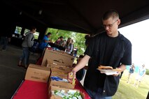 Staff Sgt. Zachery Mulhern, 5th Maintenance Group aerospace ground equipment quality assurance evaluator, walks through the burger burn line at the Rough Rider Golf Course at Minot Air Force Base, N.D., Aug. 19, 2016. The burger burn is part of the annual block party and Show and Shine Car Show. (U.S. Air Force photo by Staff Sgt. Chad Trujillo)
