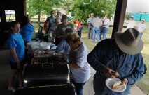 Attendees walk through the Rockers Bar and Grill burger burn line at the Rough Rider Golf Course at Minot Air Force Base, N.D.,  Aug. 19, 2016. The burger burn is part of the annual block party and Show and Shine Car Show. (U.S. Air Force photo by Staff Sgt. Chad Trujillo)