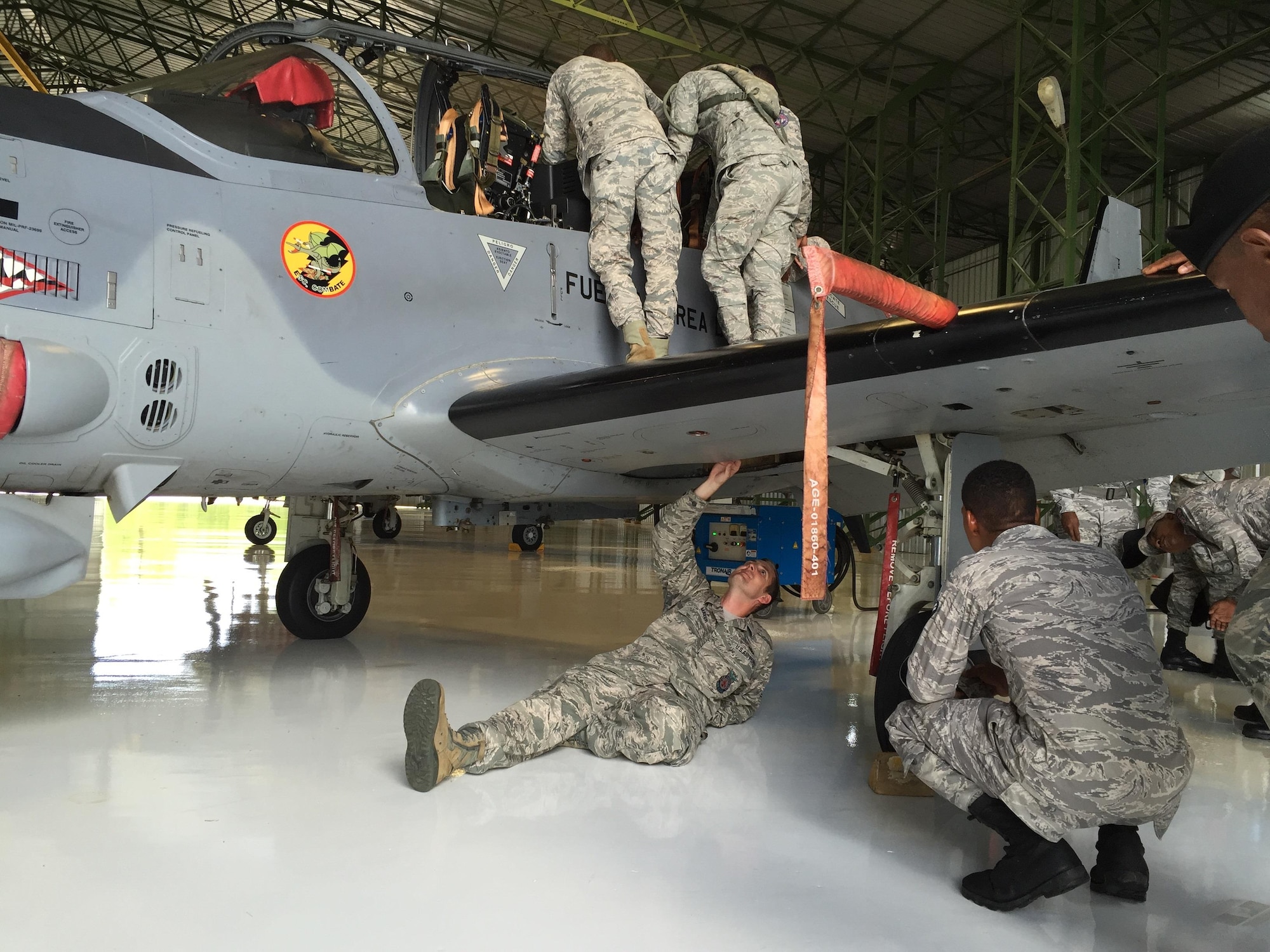 U.S. Air Force Tech. Sgt. Jonathan Mayer, 571st Mobility Support Advisory Squadron air advisor, shows Dominican Republic Airmen the hazards and shutdown procedures of the A-29 Super Tucano during a recent trip to the Dominican Republic, July 26, 2016. The 571st MSAS deployed a mobile training team from July 13 through July 31 to work with members of the Dominican Republic Air Force for the first time ever. (Courtesy Photo)