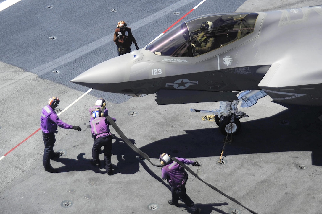 Sailors prepare to refuel an F-35C Lightning II carrier variant on the flight deck of the aircraft carrier USS George Washington in the Atlantic Ocean, Aug. 14, 2016. The sailors are aviation boatswain's mates fuel. Navy photo by Petty Officer 1st Class Alan Gragg