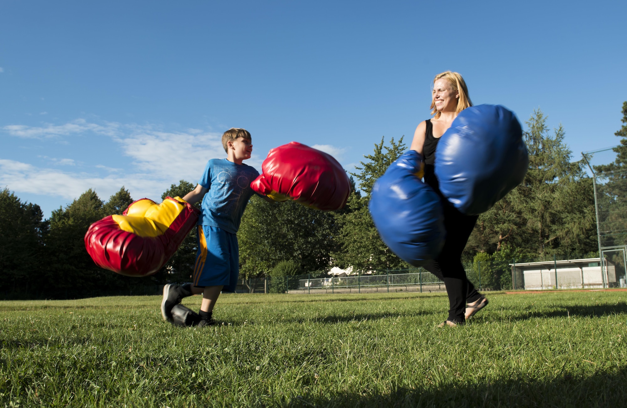 A Kaiserslautern Military Community member and her son box during the Ramstein and Vogelweh Community Center’s Olympic Family Night Aug. 22, 2016 at Ramstein Air Base, Germany. To earn a medal, children also participated in sumo wrestling, basketball, a three-legged race, a potato sack race and a “ski race”. (U.S. Air Force photo/Senior Airman Tryphena Mayhugh)