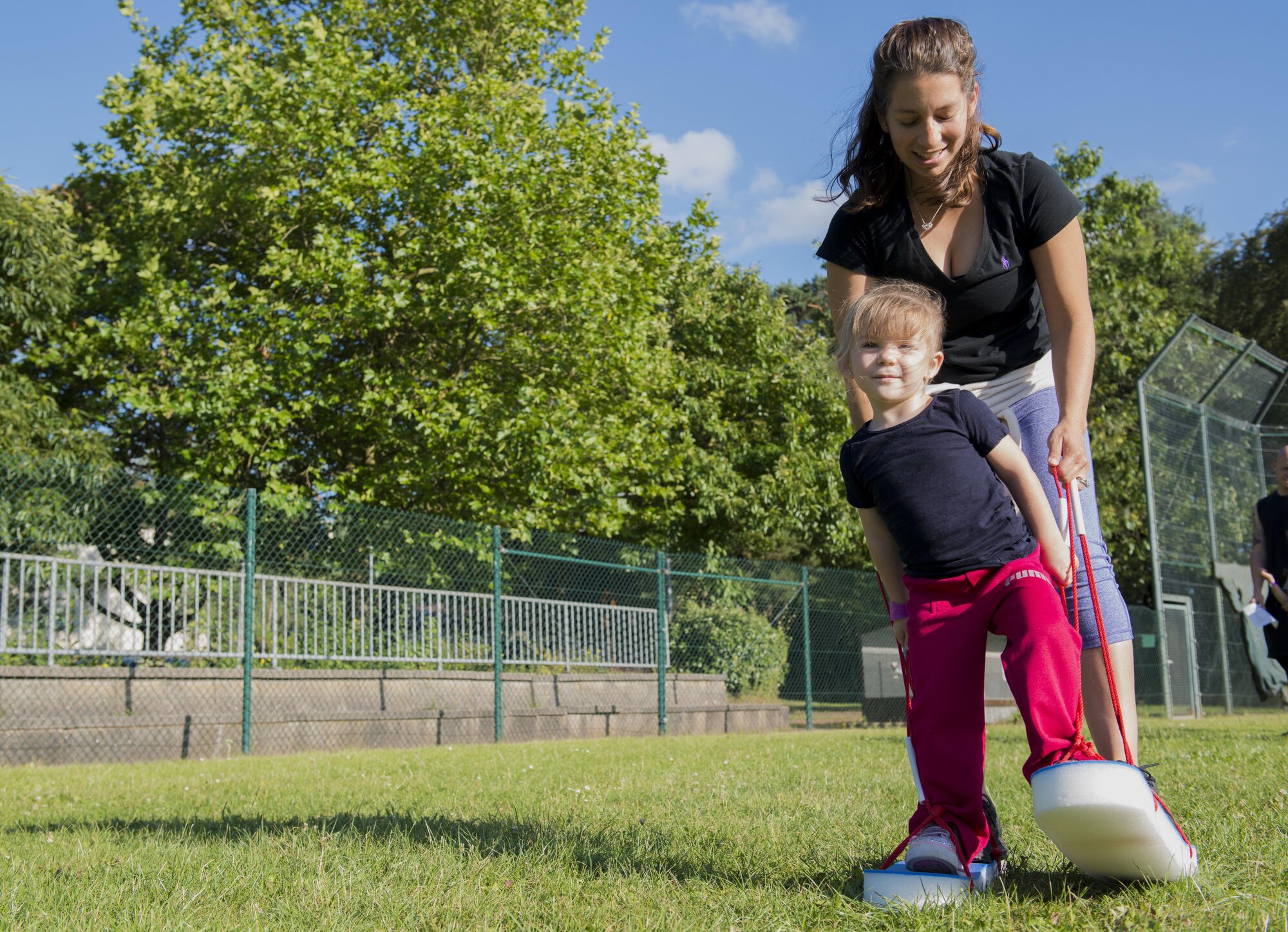 A Kaiserslautern Military Community member and her daughter “ski race” during the Ramstein and Vogelweh Community Center’s Olympic Family Night Aug. 22, 2016 at Ramstein Air Base, Germany.  Every child who completed all six events received a medal and a Pizza Gallerie free buffet coupon. (U.S. Air Force photo/Senior Airman Tryphena Mayhugh)