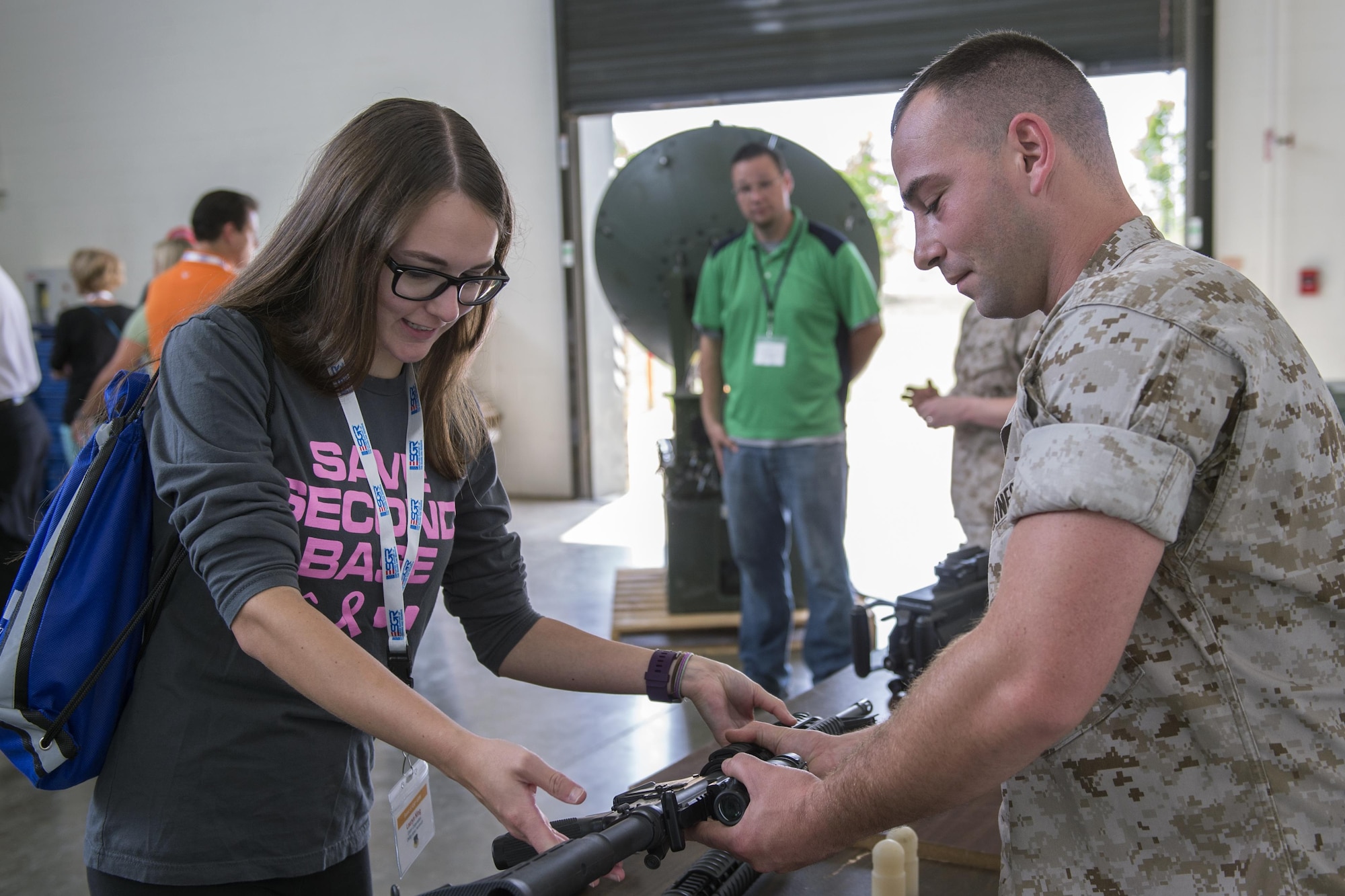 Marine Sgt. Daniel Morehouse, Detachment One, Communication Company, Combat Logistics Regiment 45, 4th Marine Logistics Group electrical engineer, hands an M4 rifle to Lauryn King, an employer participating in an orientation flight, during a tour of the Marine Corps Reserve at Grissom Air Reserve Base, Ind., Aug. 18, 2016. During the tour, employers had an opportunity to handle equipment used by the Marines and ask questions about their mission. (U.S. Air Force photo/Tech. Sgt. Benjamin Mota)