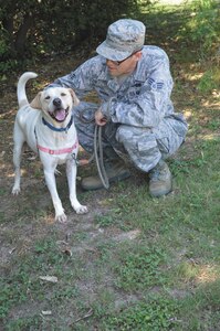 Senior Airman Lucas Dugan, 502nd Operation Support Squadron airfield systems technician, keeps Coconut, an adoptable dog, company during a volunteer outreach event June 21 at the San Antonio Pets Alive animal shelter clinic. Members of the 502nd OSS volunteer at organizations throughout San Antonio once a month to be active in the community.