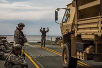 FORT MCCOY, Wis. – U.S. Army Reserve Soldiers, with the 652d Multi-Role Bridge Company out of Hammond, Wis. and from the 705th Transportation Company, from Dayton, Ohio, work together to load vehicles onto a raft made of floating bridge sections in August 2016. Then the 652d practices maneuvering a loaded raft around Petenwell Lake, Wis. The combat support training exercise allows U.S. Army Reserve units to combine their skills in real scenarios. (U.S. Army Reserve Photo by Sgt. Clinton Massey, 206th Broadcast Operations Detachment/Released)