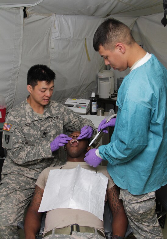 FORT MCCOY, Wis. – U.S. Army Reserve Soldier, Lt. Col. Johnie Nguyen, (left) a dentist, and Pfc. Antonio Herrera, a dental specialist, both with the 965th Dental Company, Seagoville, Texas, conduct a dental checkup on Spc. Christopher Owens, a dental specialist with the 965th, during training as part of a Global Medic Exercise at Fort McCoy, Aug. 20, 2016. (U.S. Army Reserve photo by Sgt. Quentin Johnson, 211th Mobile Public Affairs Detachment/Released)
