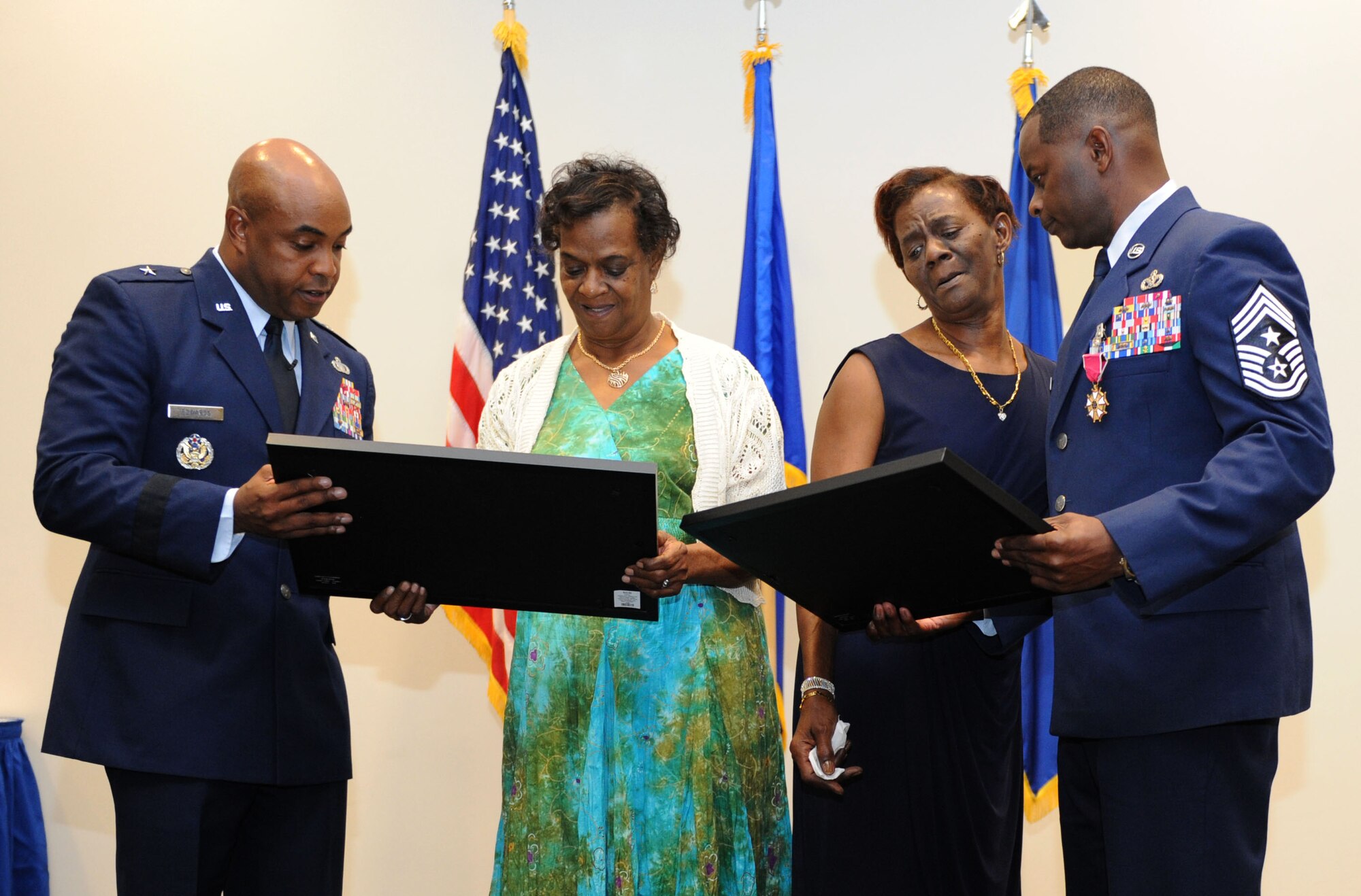 Brig. Gen. Trent Edwards, Headquarters Air Force Space Command financial management and comptroller director, Peterson Air Force Base, Colo., and Chief Master Sgt. Harry Hutchinson, 81st Training Wing command chief, present Evon Foxworth, Hutchinson’s mother, and his aunt, Veradelle Halback, with gifts during his retirement ceremony at the Roberts Consolidated Aircraft Maintenance Facility Aug. 19, 2016, on Keesler AFB, Miss. Hutchinson retired with more than 29 years of military service. He served multiple assignments in Washington, Korea, Maryland, Japan, Nevada, South Dakota and Africa. He also worked as the superintendent of the U.S. Army’s RED HORSE sites in Iraq and Afghanistan and the Air Force’s 732nd Expeditionary Prime BEEF squadron. (U.S. Air Force photo by Kemberly Groue/Released)