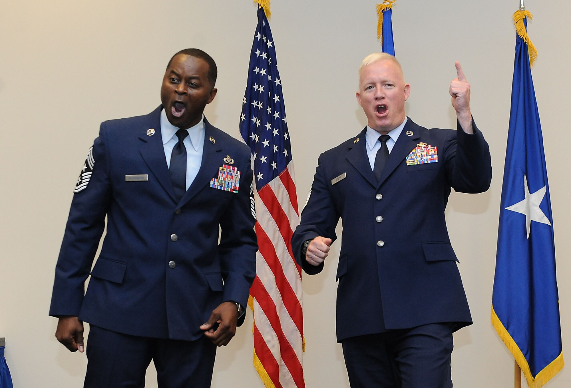 Chief Master Sgts. Harry Hutchinson, 81st Training Wing command chief, and Derick Stepp, 81st Mission Support Group superintendent, participate in a morale  chant during Hutchinson’s retirement ceremony at the Roberts Consolidated Aircraft Maintenance Facility Aug. 19, 2016, on Keesler Air Force Base, Miss. Hutchinson retired with more than 29 years of military service and served multiple assignments in Washington state, Korea, Maryland, Japan, Nevada, South Dakota and Africa. He also worked as the superintendent of the U.S. Army’s RED HORSE sites in Iraq and Afghanistan and the Air Force’s 732nd Expeditionary Prime BEEF squadron. (U.S. Air Force photo by Kemberly Groue/Released)