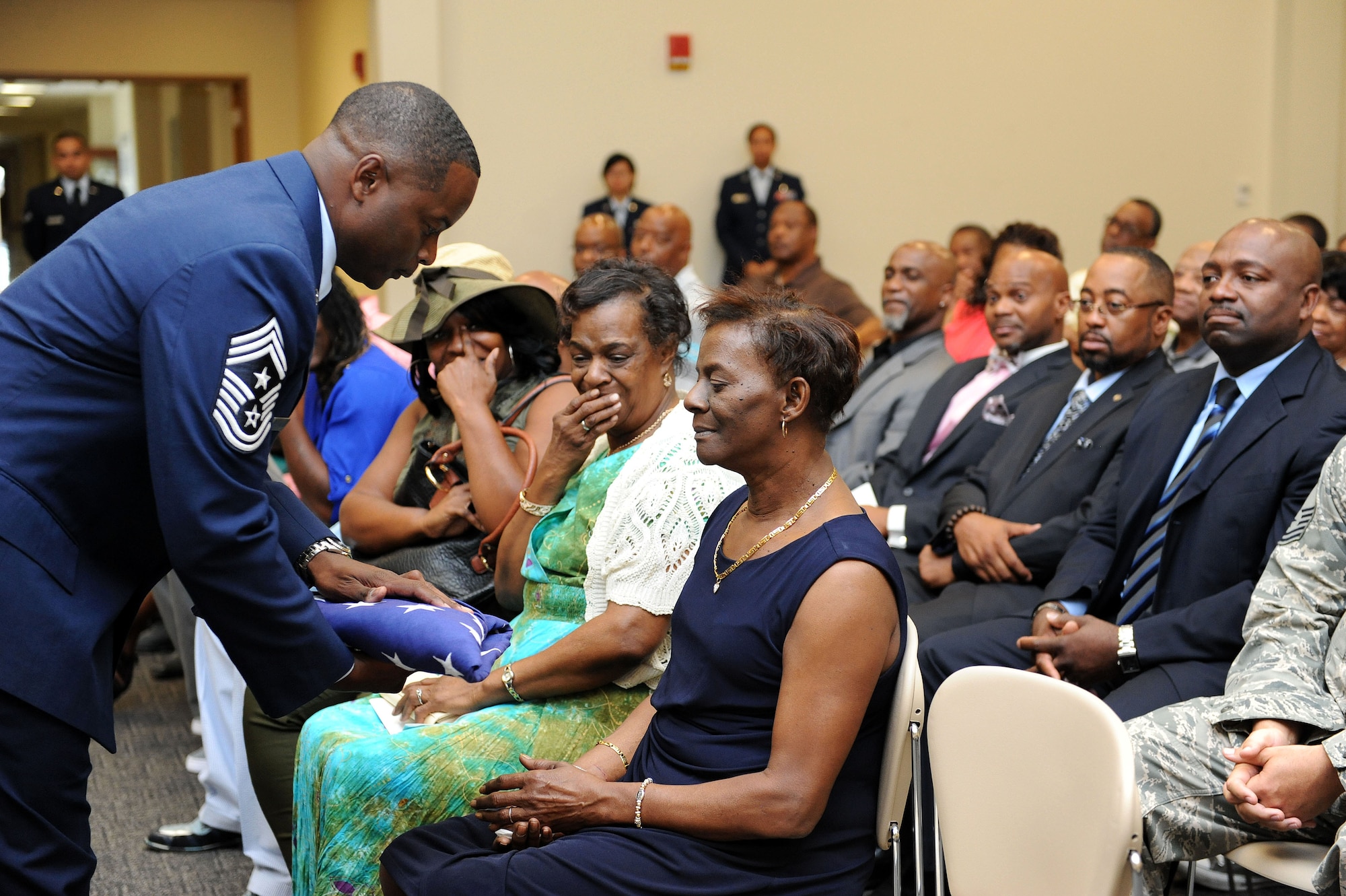 Chief Master Sgt. Harry Hutchinson, 81st Training Wing command chief, presents the U.S. flag to his mother, Evon Foxworth, during his retirement ceremony at the Roberts Consolidated Aircraft Maintenance Facility Aug. 19, 2016, on Keesler Air Force Base, Miss. Hutchinson retired with more than 29 years of military service and served multiple assignments in Washington state, Korea, Maryland, Japan, Nevada, South Dakota and Africa. He also worked as the superintendent of the U.S. Army’s RED HORSE sites in Iraq and Afghanistan and the Air Force’s 732nd Expeditionary Prime BEEF squadron. (U.S. Air Force photo by Kemberly Groue/Released)