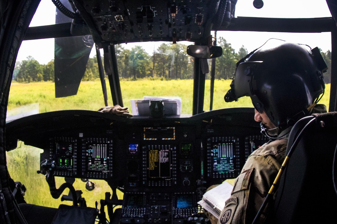 An Army pilot shuts down his CH-47 Chinook helicopter on a drop zone before transporting soldiers and artillery to support of a gun raid and live-fire exercise at Fort Bragg, N.C., Aug 12, 2016. Army photo by Capt. Adan Cazarez