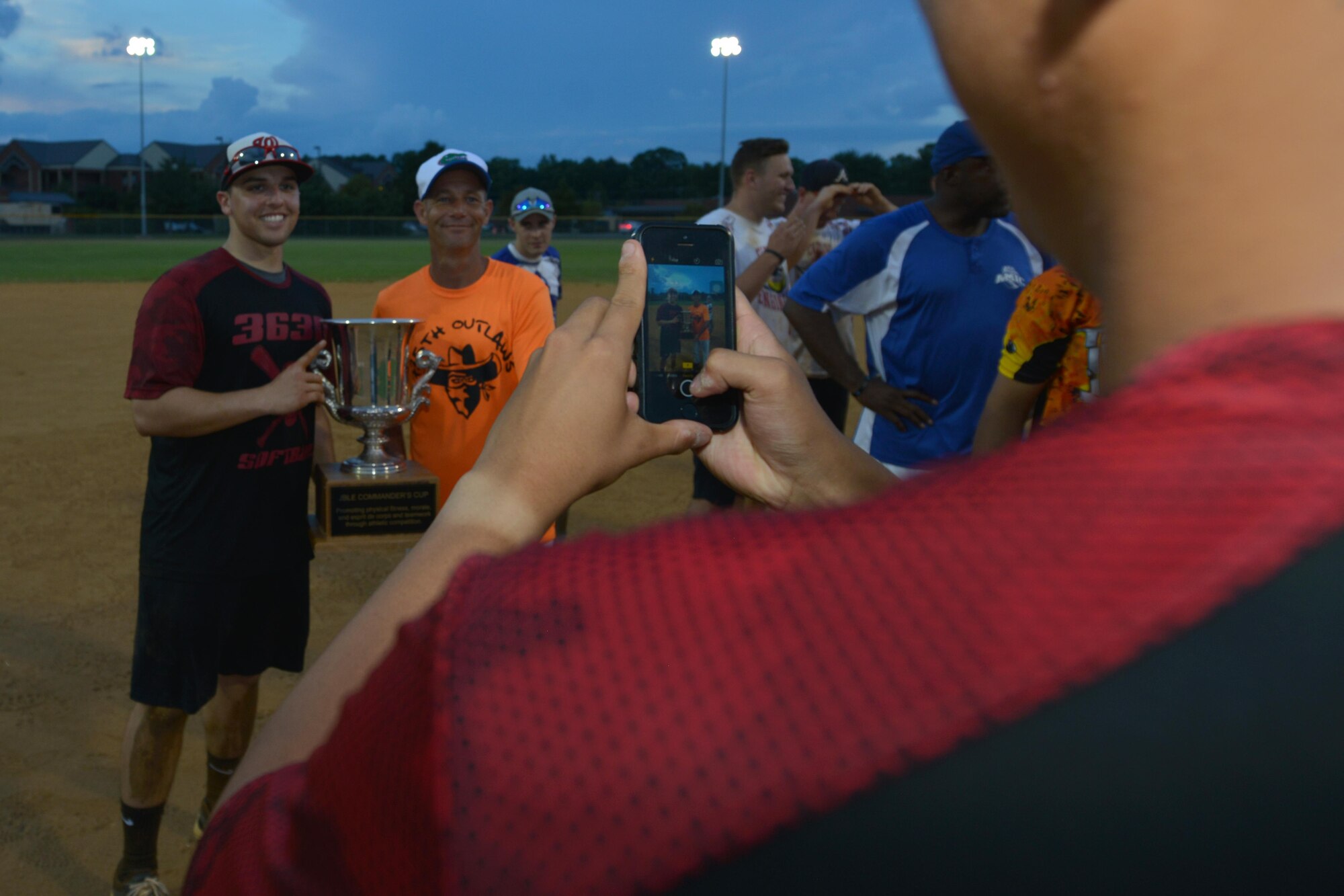 U.S. Air Force Tech. Sgt. Thomas Randle, middle, Langley All-Stars head coach, takes photos with his team after   the Joint Base Langley-Eustis Commander’s Cup Softball Championship game at Fort Eustis, Va., Aug. 17, 2016. The Langley All-Stars clinched a victory over the Fort Eustis All-Stars making them the reigning champions. (U.S. Air Force photo by Staff Sgt. Nastasha Stannard)