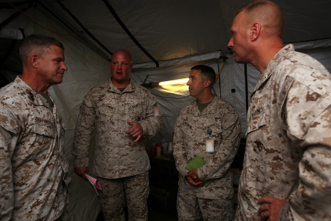 U.S. Marine Lt. Col. Eric Beckmann (center left) speaks to Lt. Gen. Lewis A. Craparotta (left), Maj. Daniel Gohlke (center right) and Col. James R. Hensien (right) during the I Marine Expeditionary Force Large Scale Exercise 16 at Camp Pendleton, Calif., Aug. 19, 2016. Craparotta is the I MEF commanding general, Beckmann is the 1st Marine Logistics Group G-3 assistant chief of staff, Daniel Gohlke is the 1st MLG G-2 AC/S, and Hensien is the 1st MLG chief of staff. LSE 16 tests I MEF’s ability to plan, deploy, and command and control a force of more than 50,000 Marines and Sailors against a near-peer enemy force. The exercise tests 1st MLG’s ability to provide sufficient, agile, flexible and responsive tactical level logistics to I MEF forces in support of operations. (U.S. Marine Corps photo illustration by Sgt. Laura Gauna/ released)