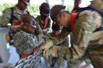 Maritime and Intermodal Training Department students work together to tighten down a transport vehicle to a simulated aircraft at Fort Eustis, Va., Aug. 22, 2016.  Before the students practiced this skill, instructors emphasized the importance of ensuring the vehicle is completely immobilized for aerial transport. (U.S. Air Force photo by Staff Sgt. Natasha Stannard)